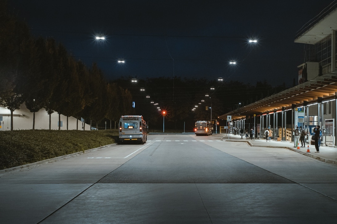 Bussar med stark LED-belysning på en terminal under natten, vilket illustrerar vikten av bra ljus i mörker.